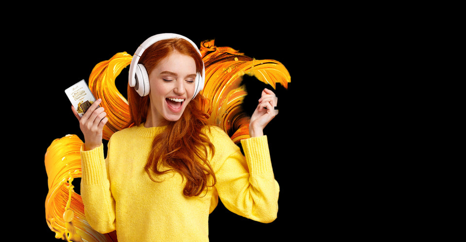 Woman with headphones holding a chocolate bar on an orange background with text 'Listen to your chocolate craving'.